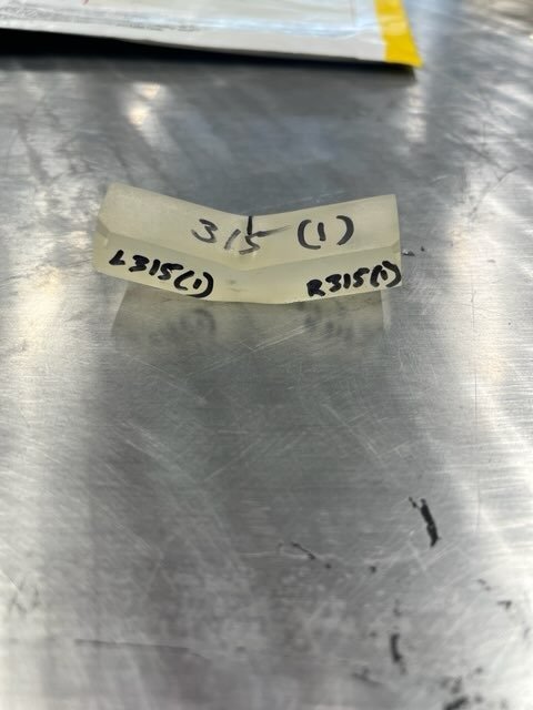 Bent polymer specimen with lab markings